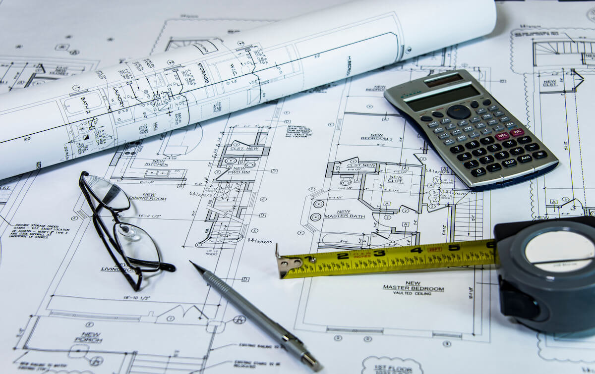Blueprints, calculator and measuring tools used to review a new-home plan