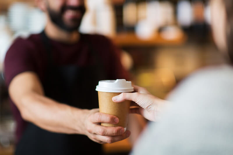 A coffee being handed across the counter at a Calgary café
