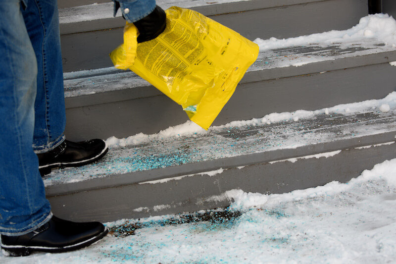 De-icer being applied to icy outdoor stairs