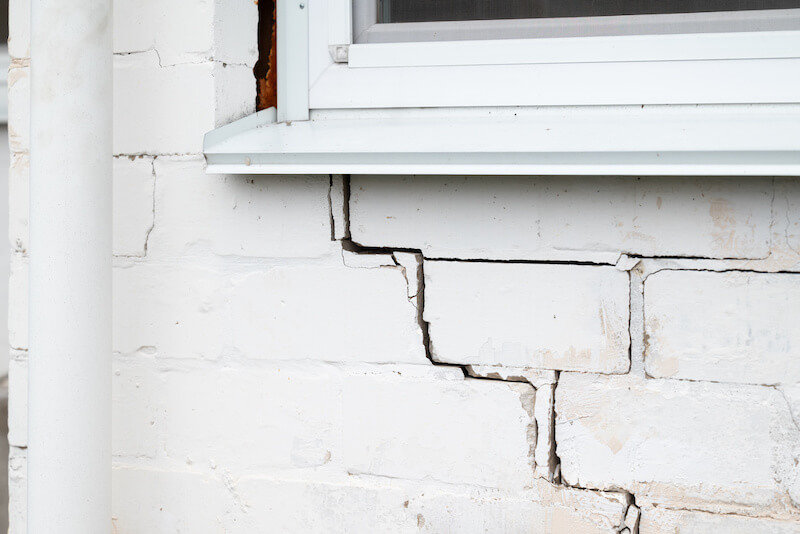 Visible cracking near a window on an older exterior wall